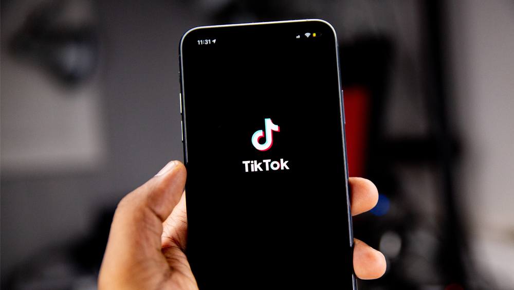 person holding phone with TikTok open on screen
