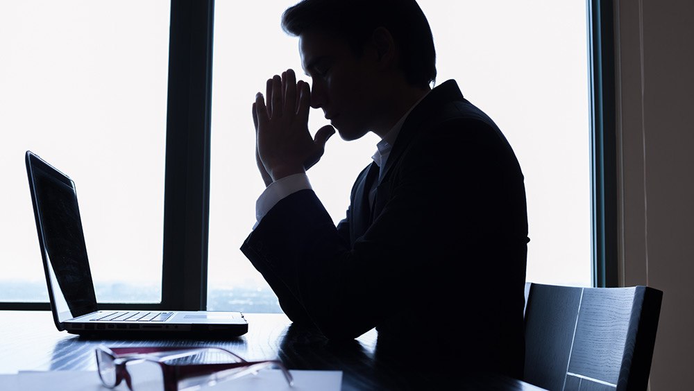 businessman praying in office