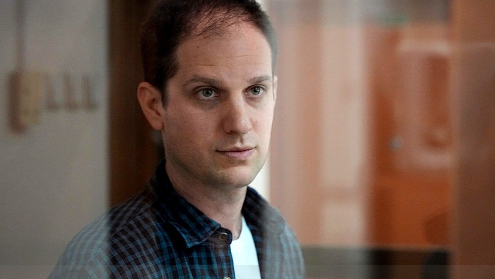 Wall Street Journal reporter Evan Gershkovich stands in a glass cage in a courtroom at the Moscow City Court