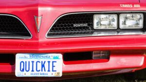 Red Pontiac with custom license plate with word "quickie" written on it