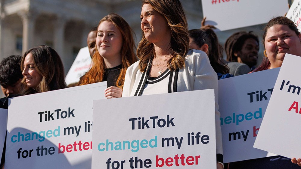 People hold signs outside the U.S. Capitol on March 12, 2024, opposing the TikTok bill.