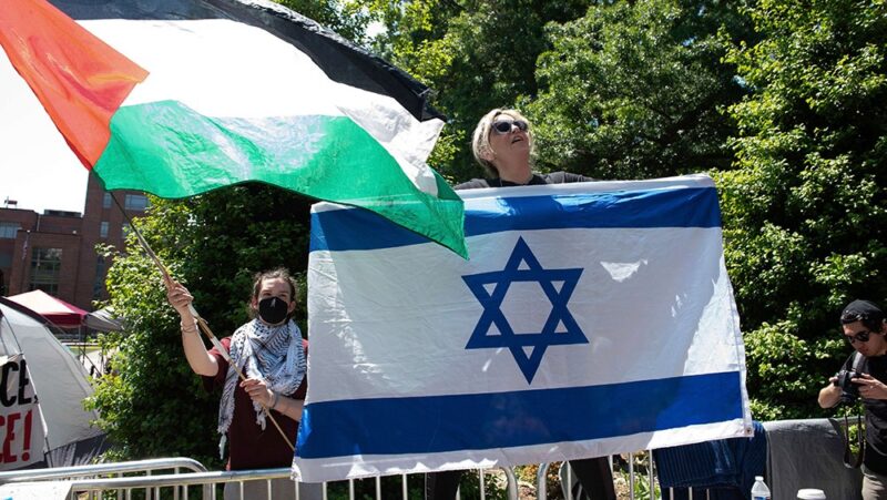 Protestors wave Israeli and Palestinian flags during a demonstration against the Israel-Hamas war at George Washington University.