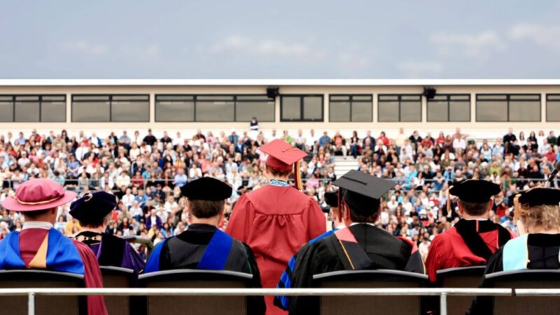 Rear view of valedictorian giving a speech during college commencement ceremony.