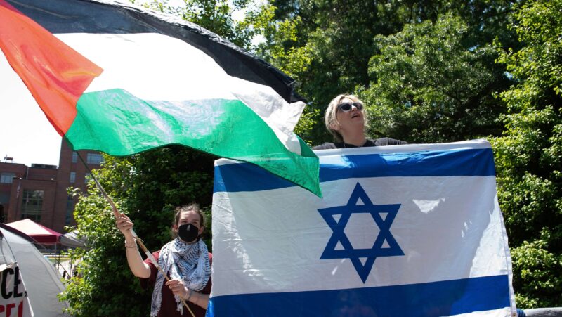 Protestors wave Israeli and Palestinian flags during a demonstration against the Israel-Hamas war at George Washington University.
