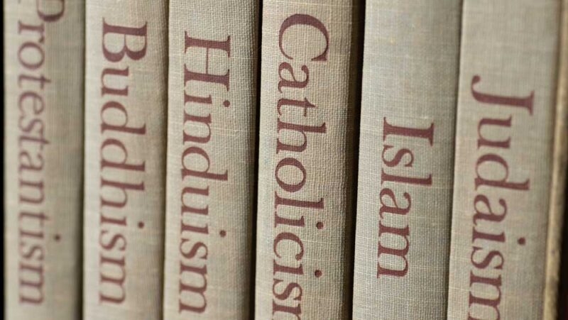 Book spines listing six major world religions