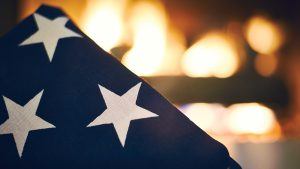 Stars of folded American flag in front of a fire