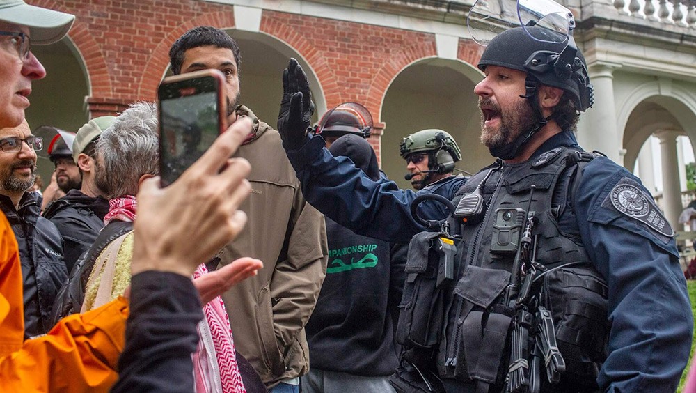 Police move demonstrators back from the grounds of the University of Virginia.