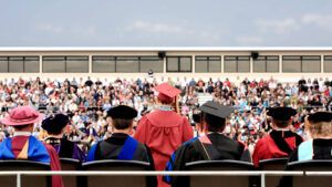 Rear view of valedictorian giving a speech during college commencement ceremony.