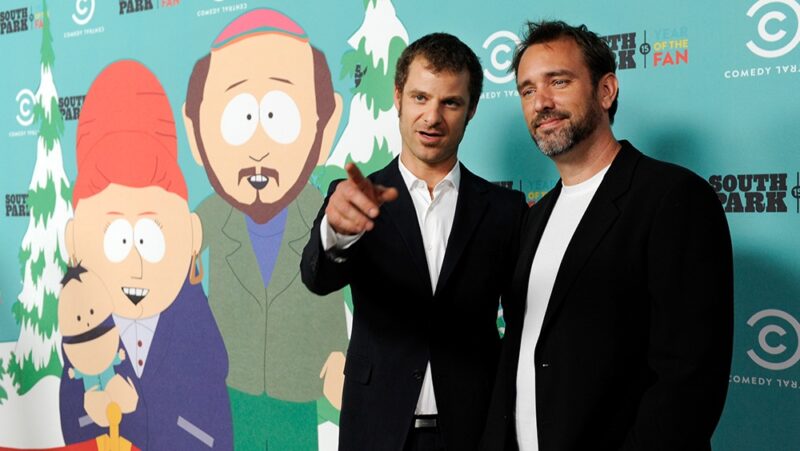 South Park creators Matt Stone and Trey Parker standing in front of South Park backdrop