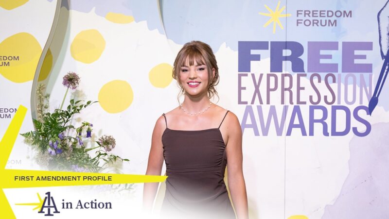 Claire Vlases standing in front of photo wall at 2024 Free Expression Awards