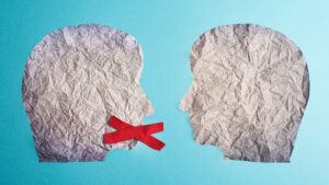 Viewpoint discrimination concept showing two paper silhouette faces looking at each other, one with a red cross over its mouth