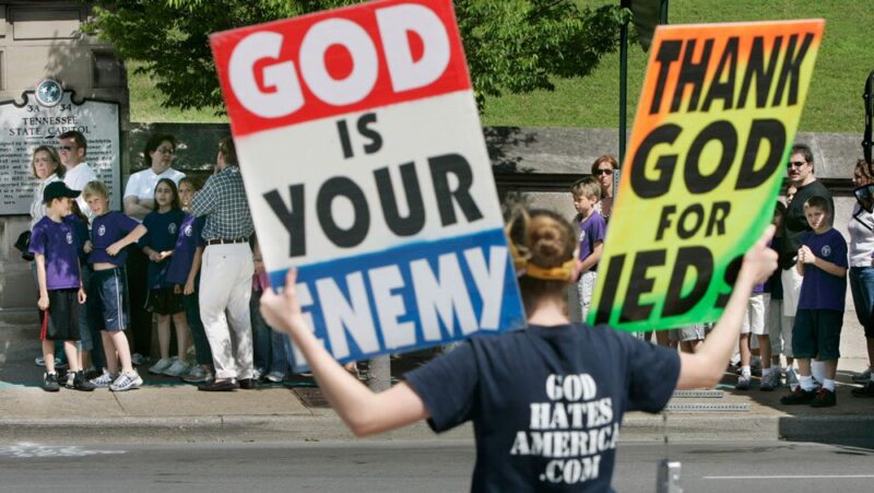 An image of a person holding signs that read 