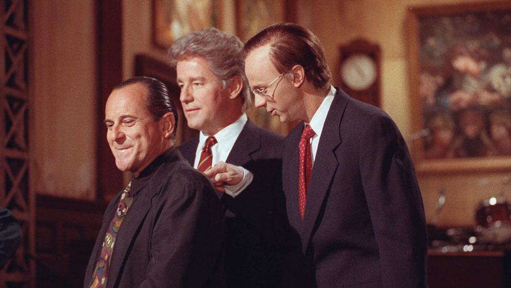 Photo shows three actors on SNL wearing suits