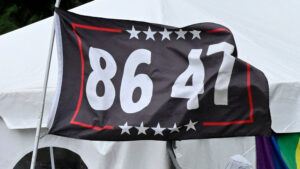 A dark blue flag with a border of white stars and red lines says "86 47"