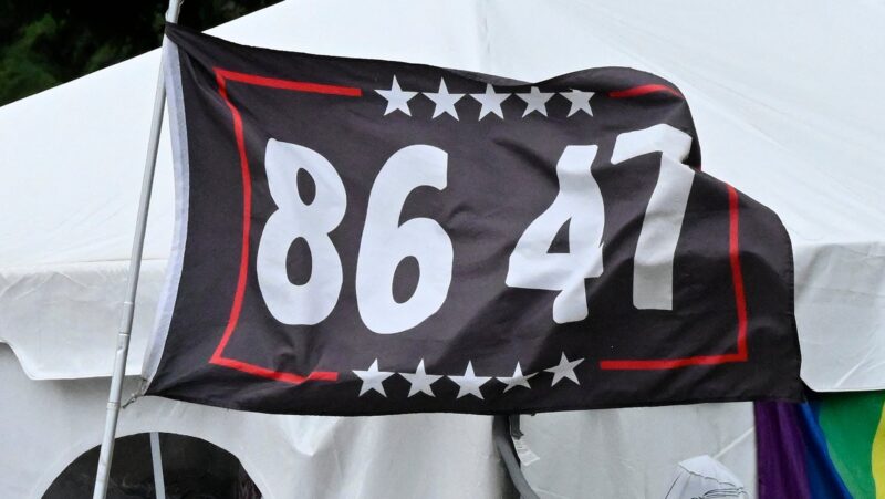A dark blue flag with a border of white stars and red lines says 